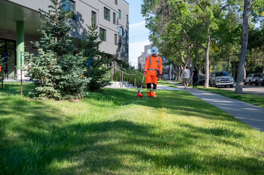 Close-up of EPCOR employee and community member looking at permeable pavement blocks, which are designed to absorb rainwater and reduce runoff in sustainable urban infrastructure.