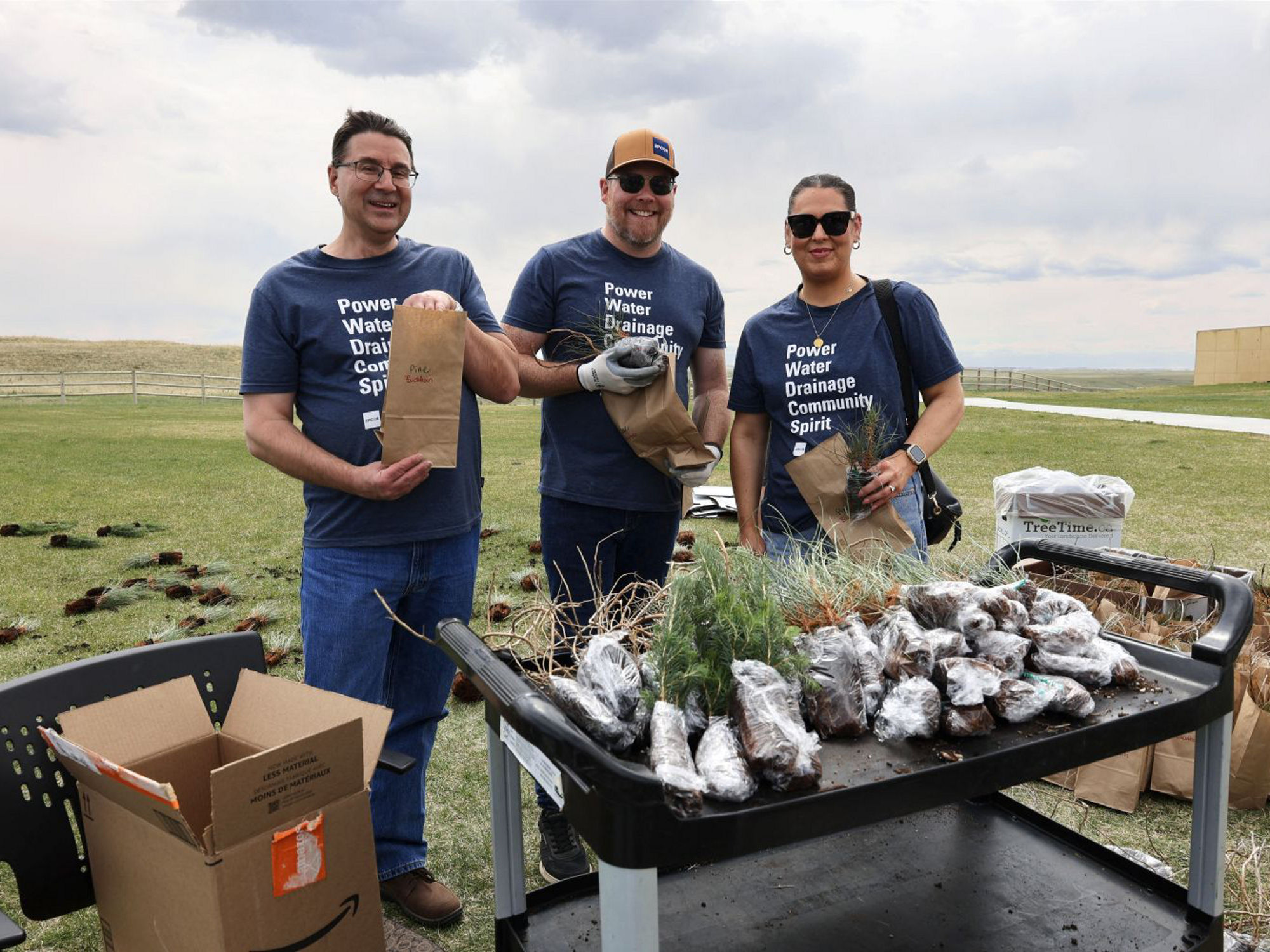 Three EPCOR employees planting trees at Siksika Nation.