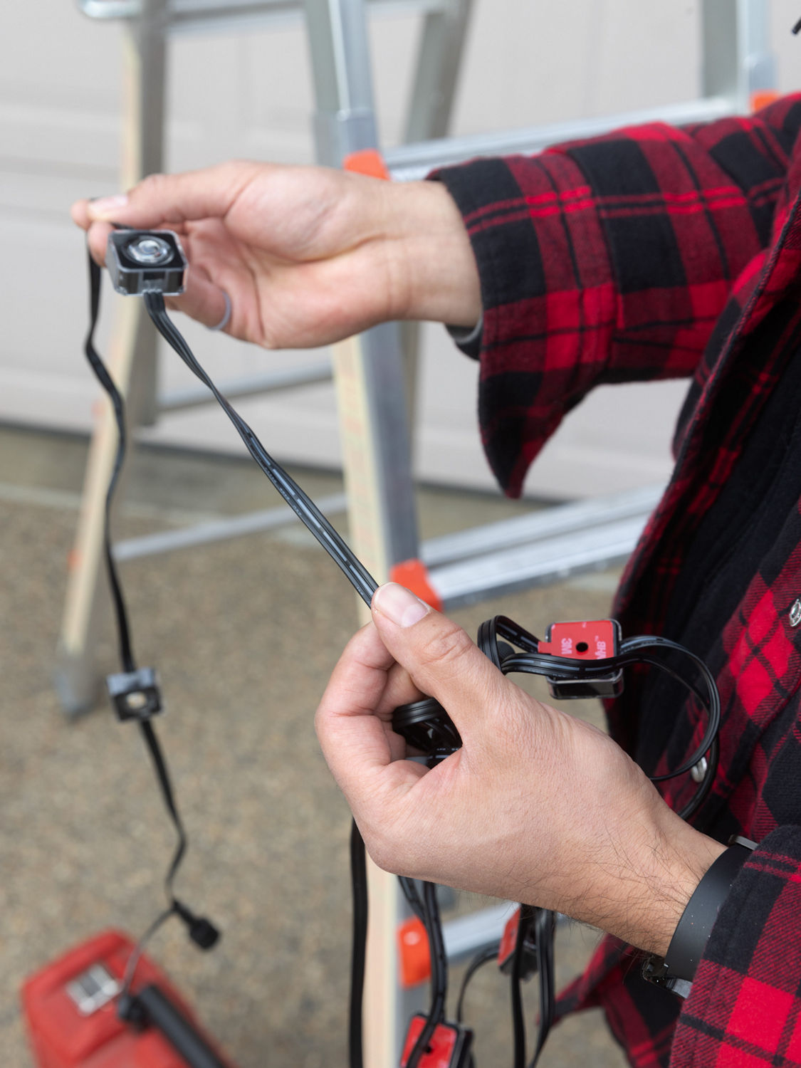 Someone holding outdoor string lights for inspection