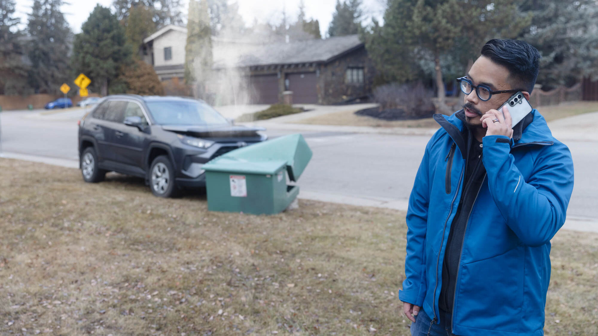 Someone calling to report a car has hit and damaged a green electrical box.