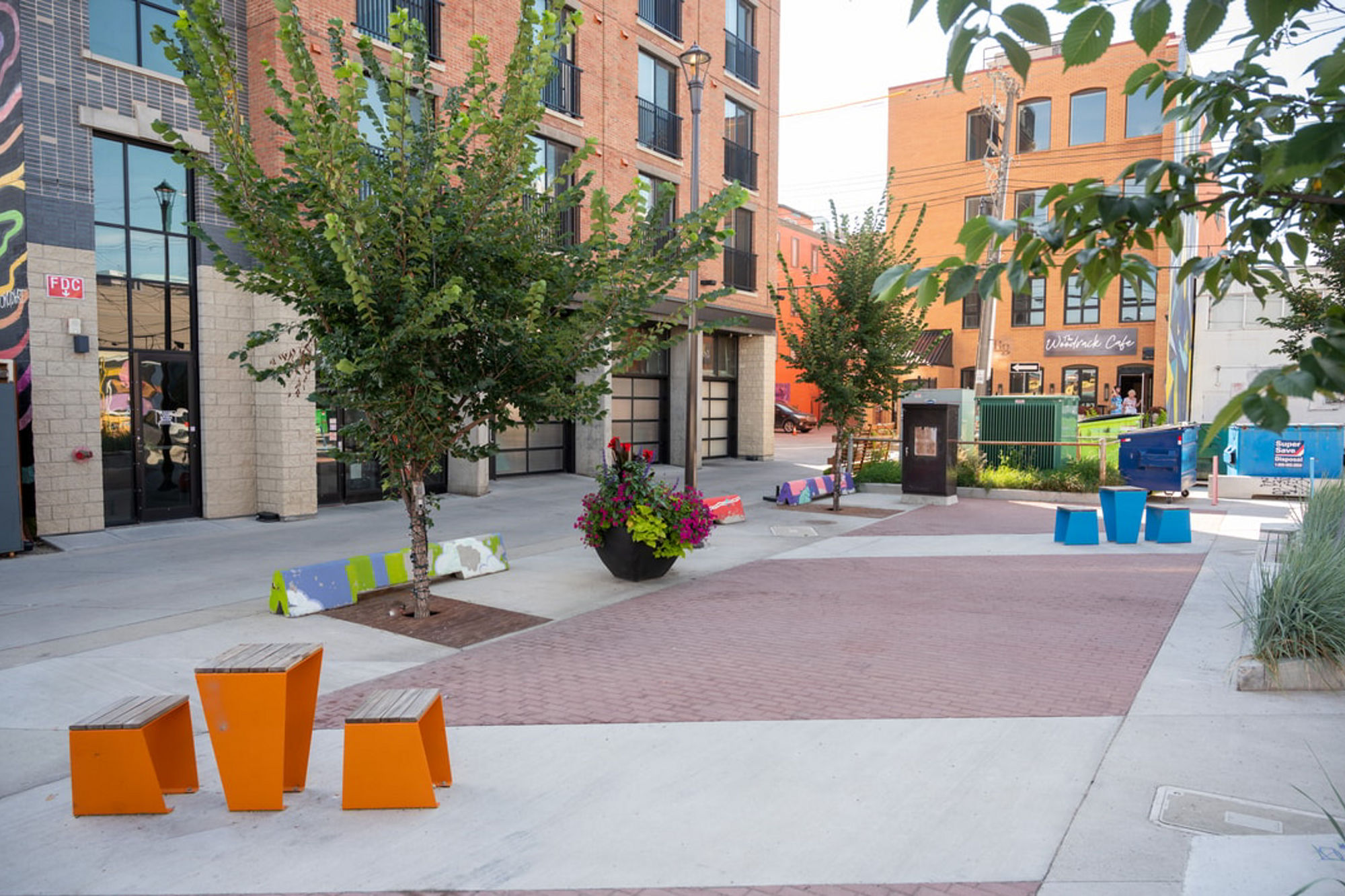 A modern plaza with trees and seating, built over soil cells to support root growth and manage stormwater beneath hard surfaces.