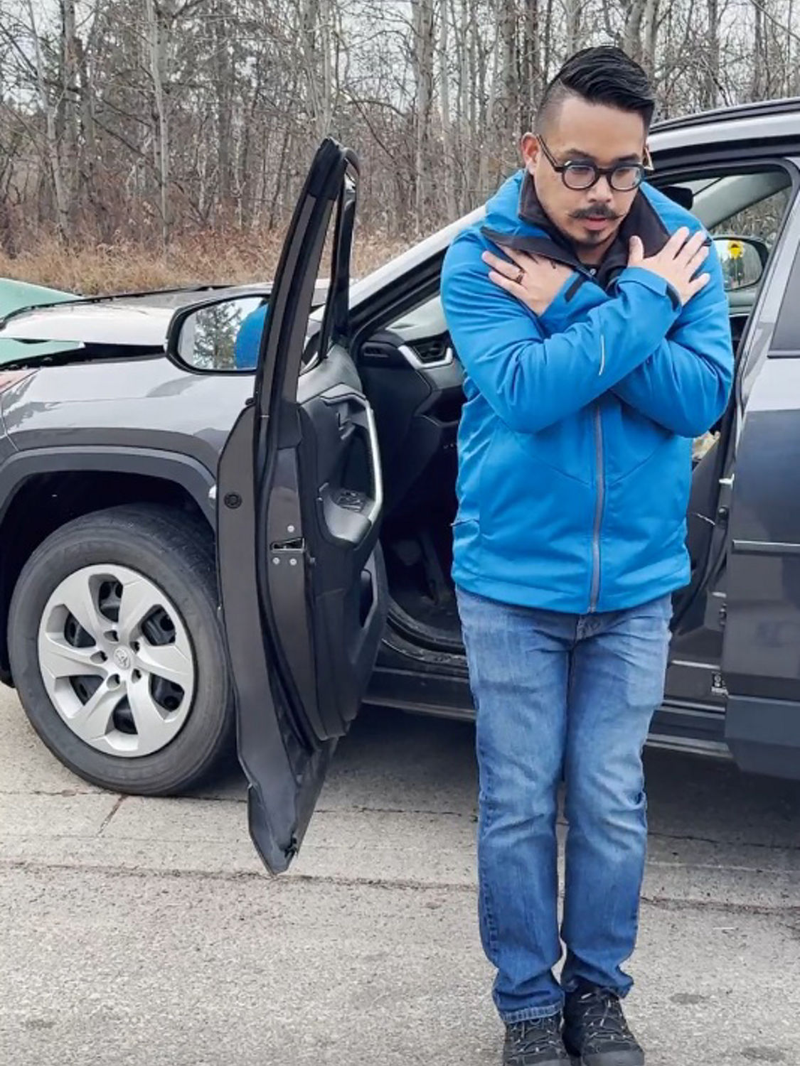 Someone that hit a green electrical box has exited vehicle and is shuffling away.