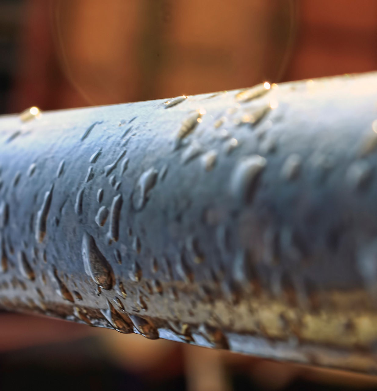 drops of dew on an iron pipe close up