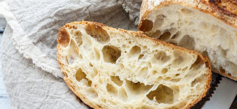 Cut a loaf of artisanal bread on sourdough.