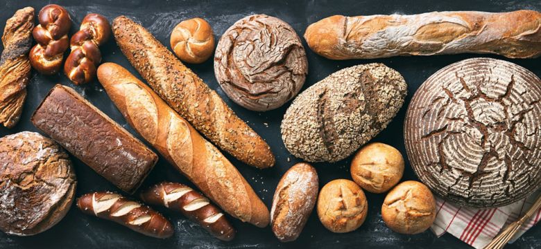 Delicious freshly baked bread assortment on dark rustic background
