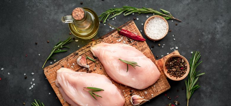 
Raw chicken fillet on a cutting board with rosemary, spices, tomatoes and pepper on a stone background; Shutterstock ID 1582498705; purchase_order: KFT; job: Europe; client: Marketing