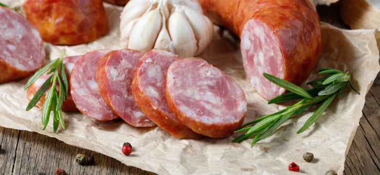 Smoked sausage on a wooden table. Rustic style.