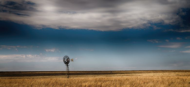 Metal windmill in field