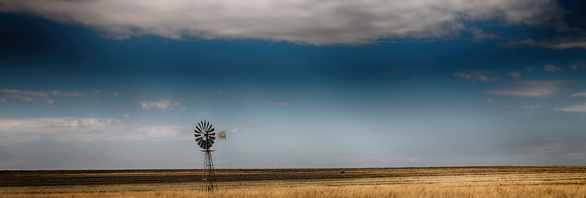 Metal windmill in field