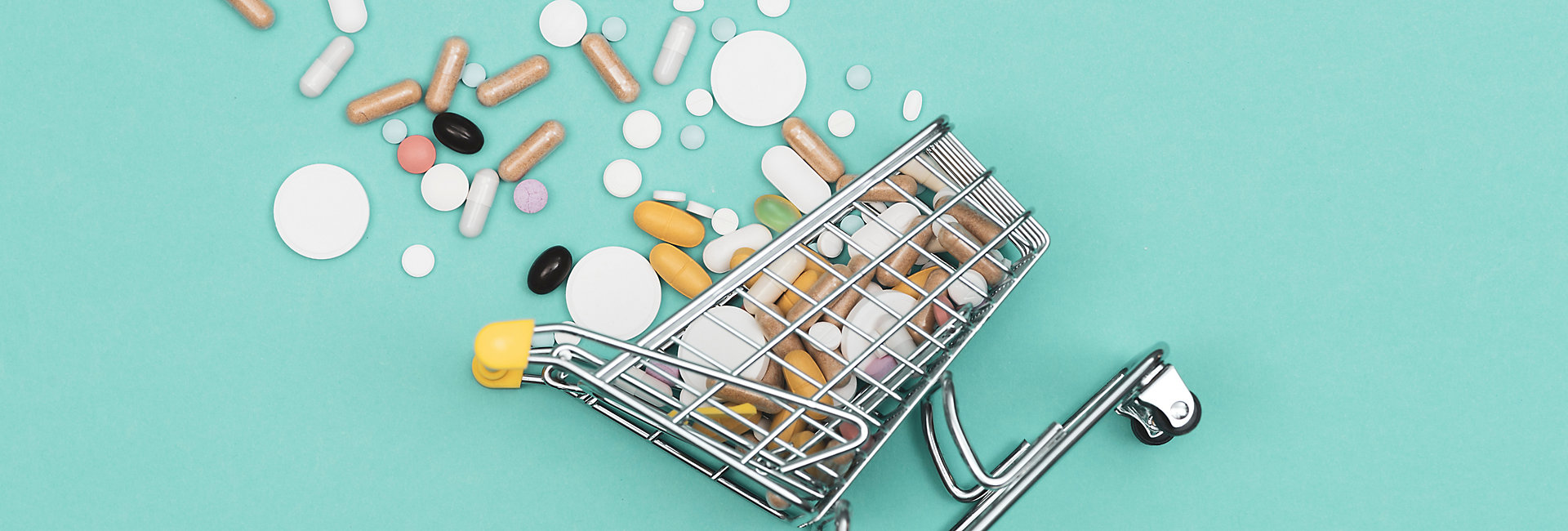 Miniature shopping cart filled with pills, tablets and capsules: pharmacy shopping, medicine and drug abuse concept; Shutterstock ID 1378202222; purchase_order: -; job: -; client: -
