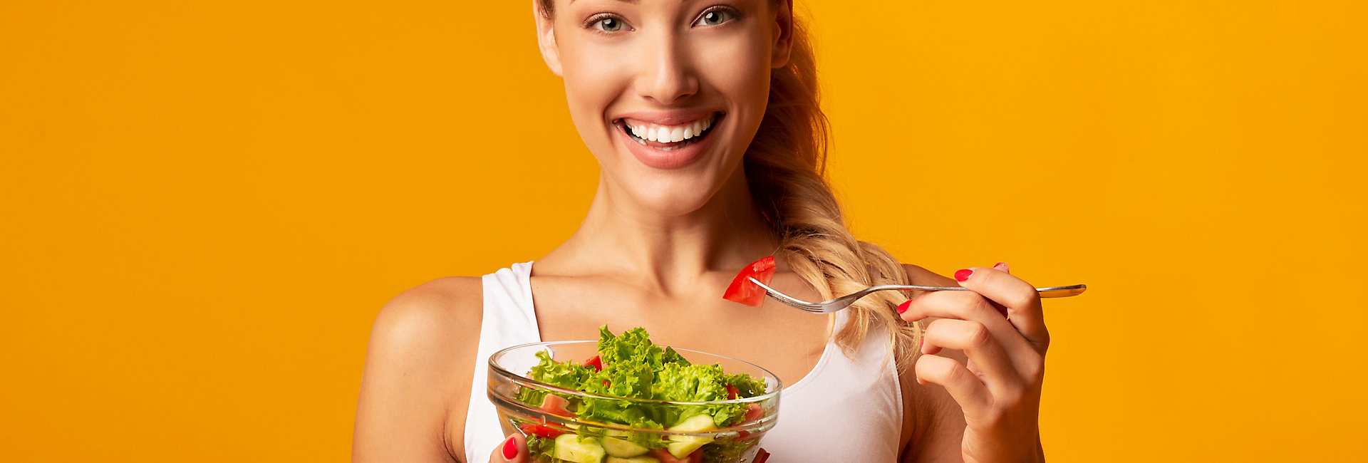 Sport And Diet. Cheerful Fitness Girl Eating Vegetable Salad Standing In Studio Over Yellow Background.; Shutterstock ID 1513976609; purchase_order: -; job: -; client: -