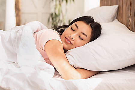 Asian Woman Sleeping Lying In Bed At Home Hugging Pillow On Weekend Morning. Healthy Sleep Concept