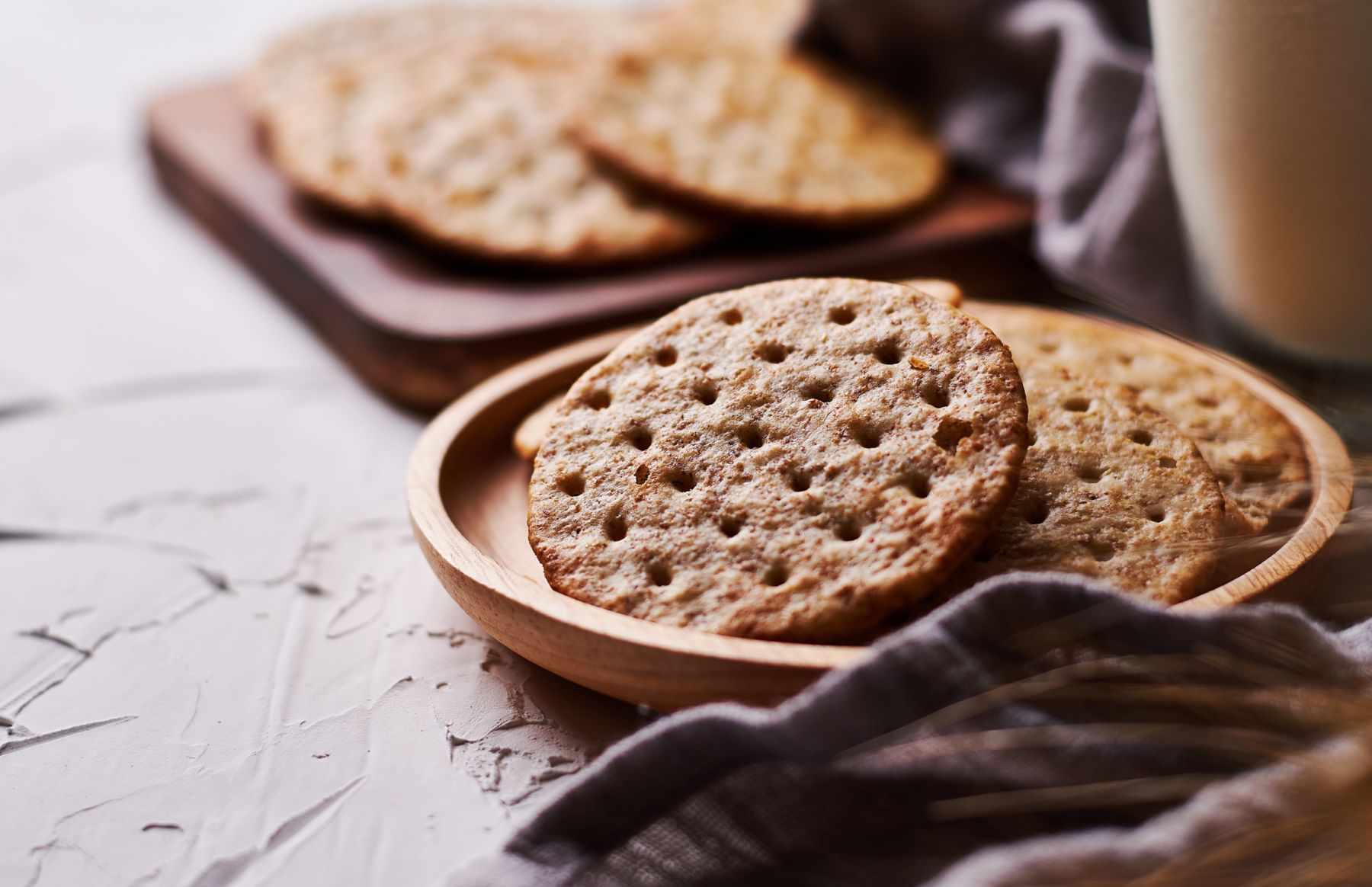 whole grain wheat round crackers and milk on white table background