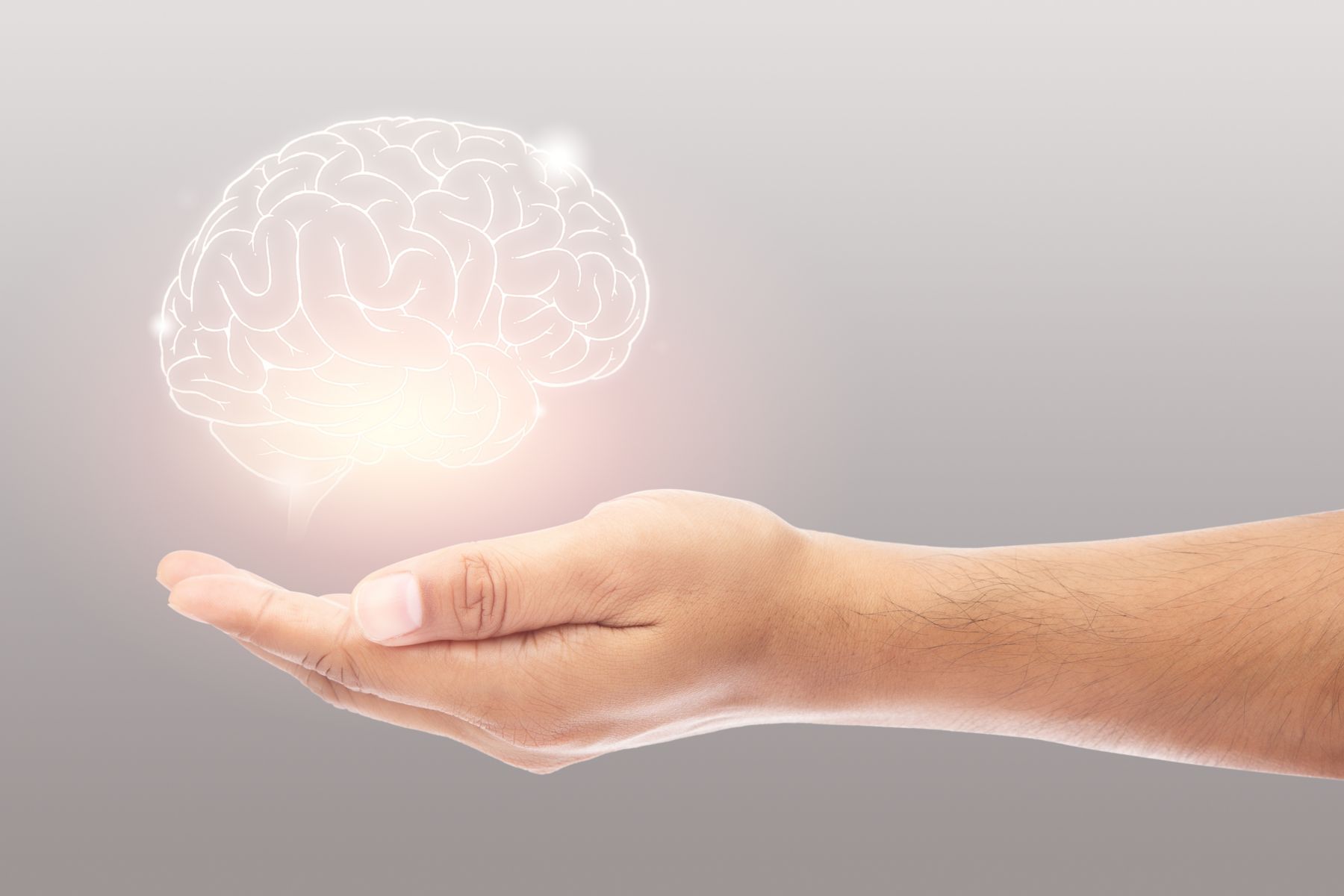 Man holding brain illustration against gray wall background. Concept with mental health protection and care.	; Shutterstock ID 1925676119; purchase_order: -; job: -; client: -