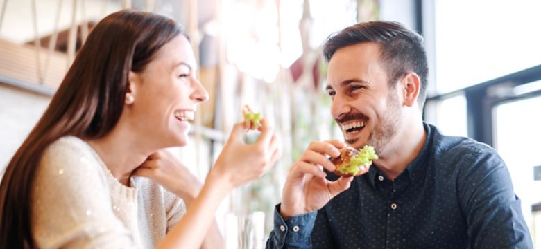 Happy loving couple enjoying breakfast in a cafe. Love, dating, food, lifestyle