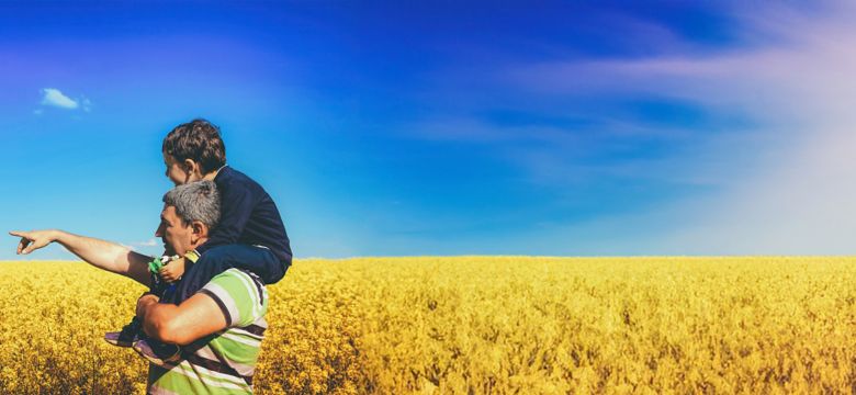 Father and son look upon farm fields