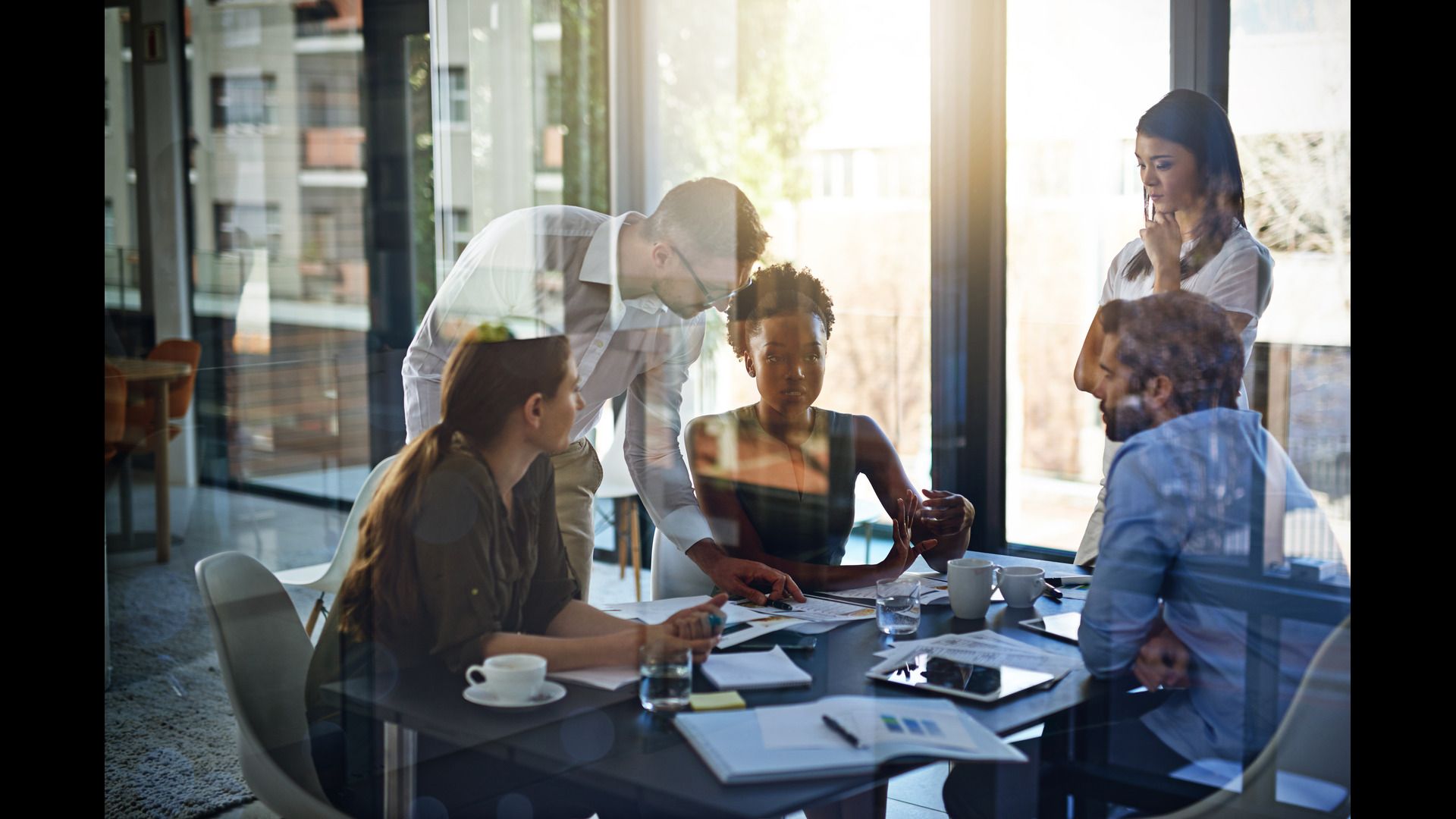 Five colleagues collaborating around a conference room table. 