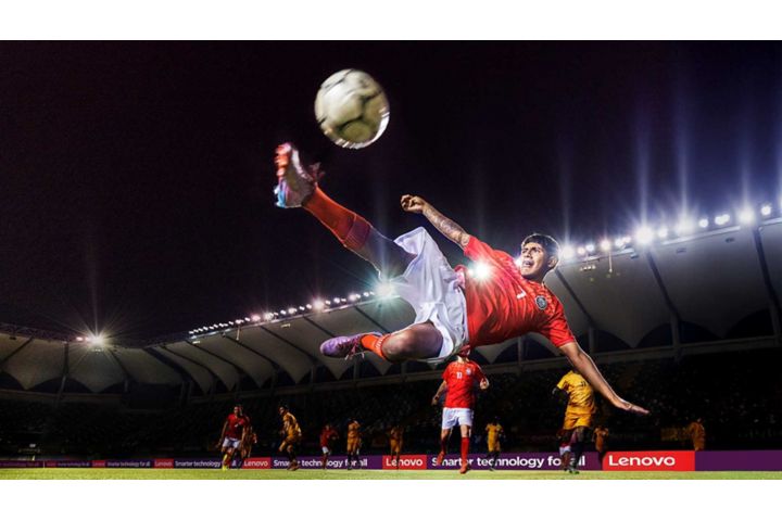 A football player kicking the ball in mid-air. 