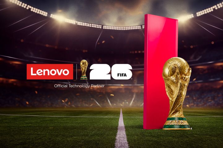 A football stadium with the red Lenovo portal on the pitch next to the men’s  World Cup trophy, and the logos of Lenovo and FIFA World Cup 26. Official Technology Partner. 
