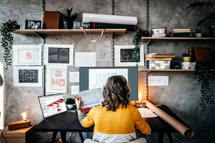 Architect using a ThinkPad laptop to review building plans and design drawings