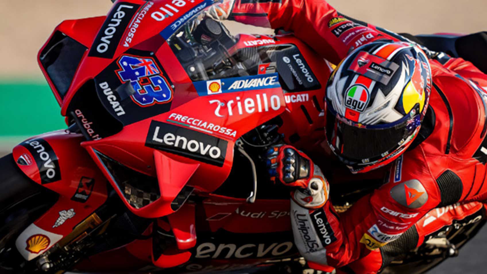 Un pilote de moto Ducati Corse prenant un virage serré. 