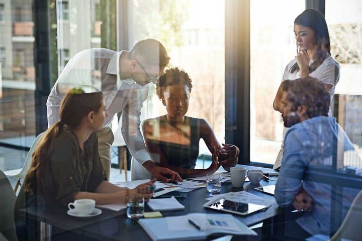 Five colleagues collaborating around a conference table.