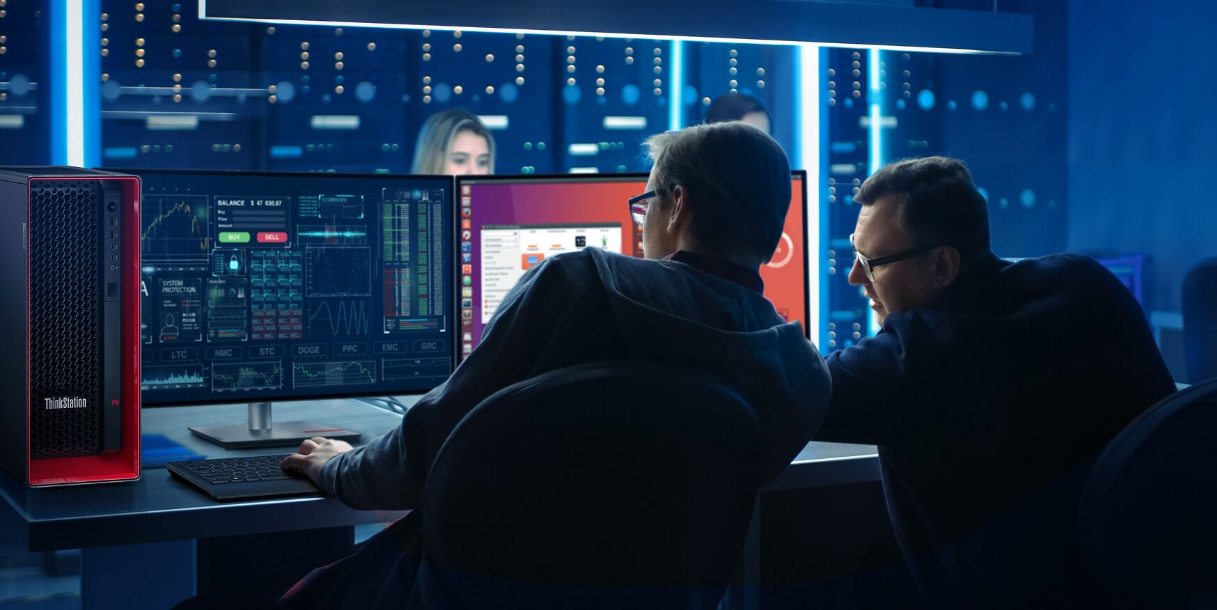Two colleagues in a dark room looking at monitors. 