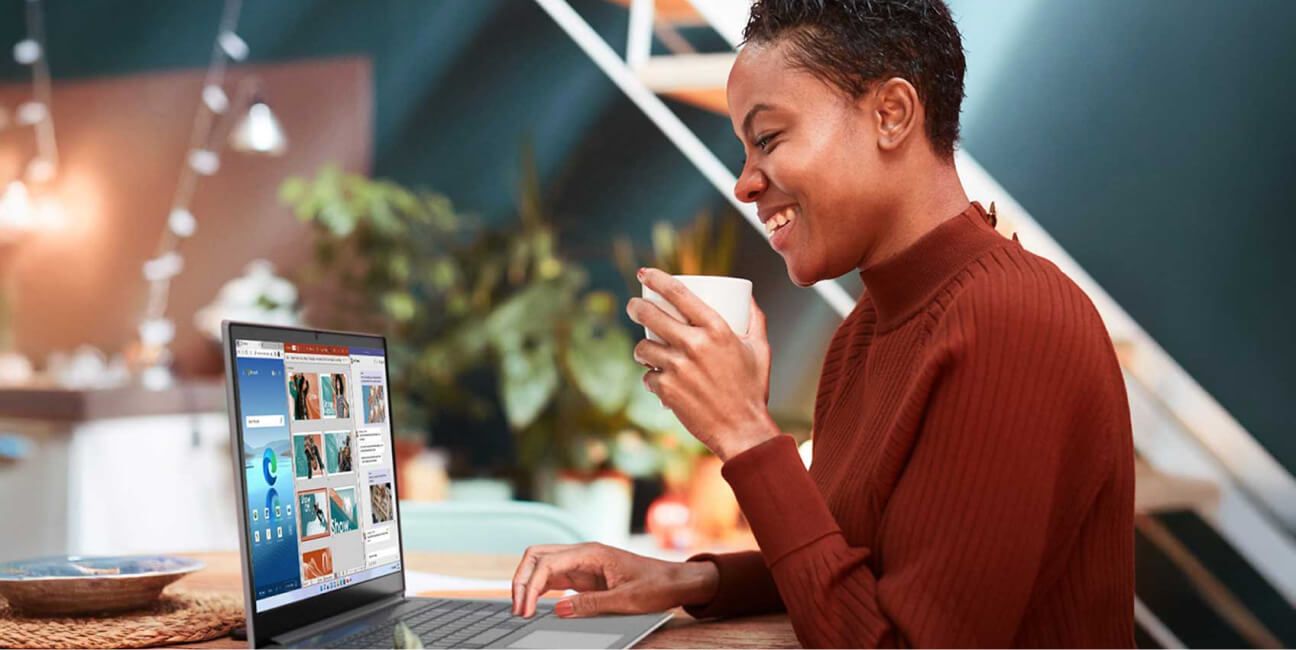  A woman using her laptop and drinking coffee.