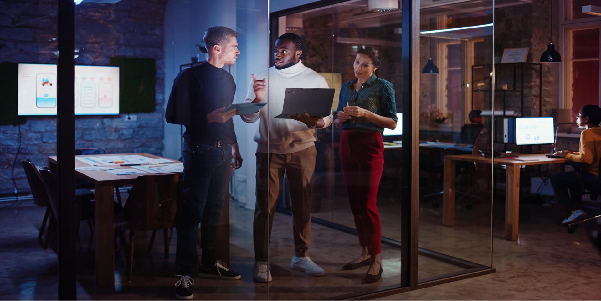 Three colleagues collaborating in a conference room.