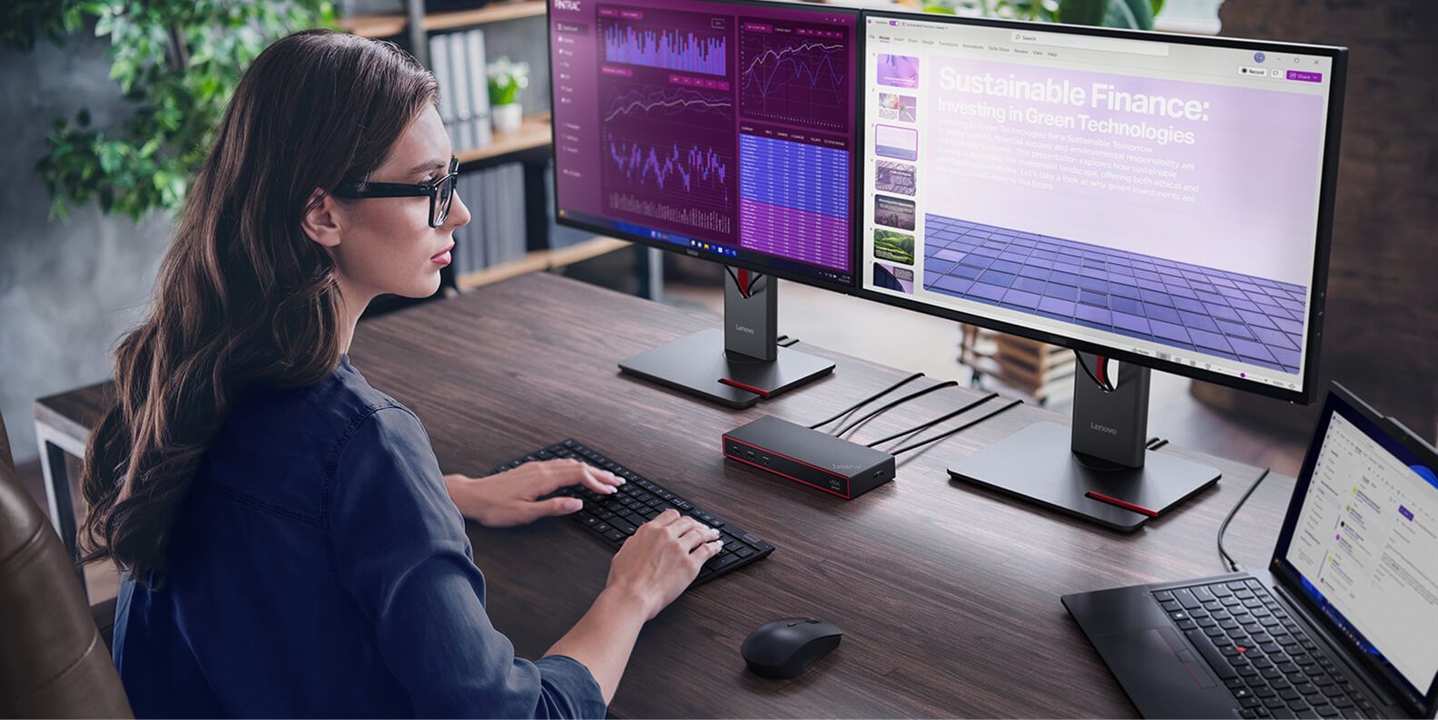 A woman using a laptop, two monitors, a docking station, and wireless keyboard and mouse.
