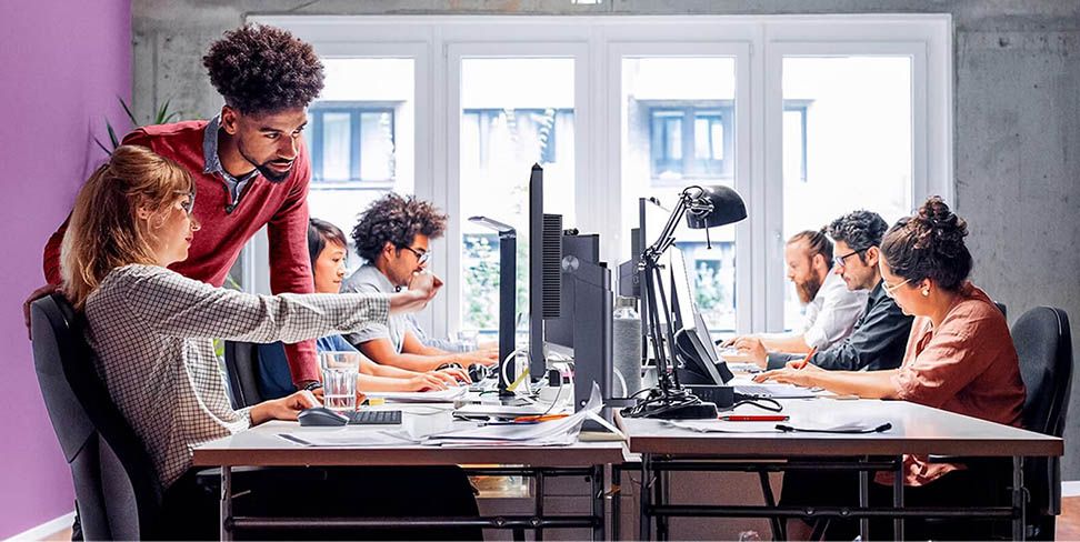 Rows of desk with people working at computers.