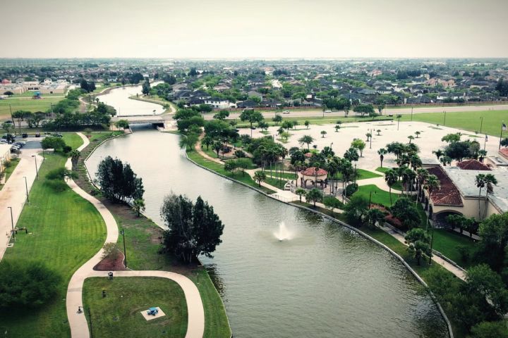 Aerial view of a canal, green spaces, and urban residential area.