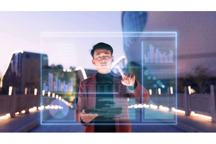 A man holding a tablet and using his finger to write on glass.