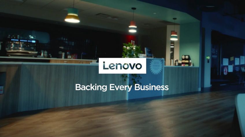 モダンなカフェの内装に重なる Lenovo のロゴと、画面に表示された「Backing Every Business」のテキスト。 