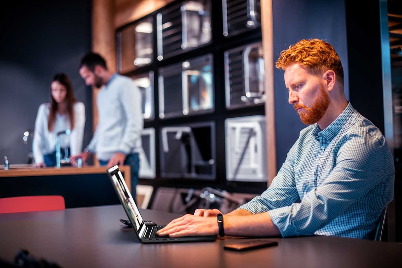 Um homem em um escritório trabalhando em seu laptop.