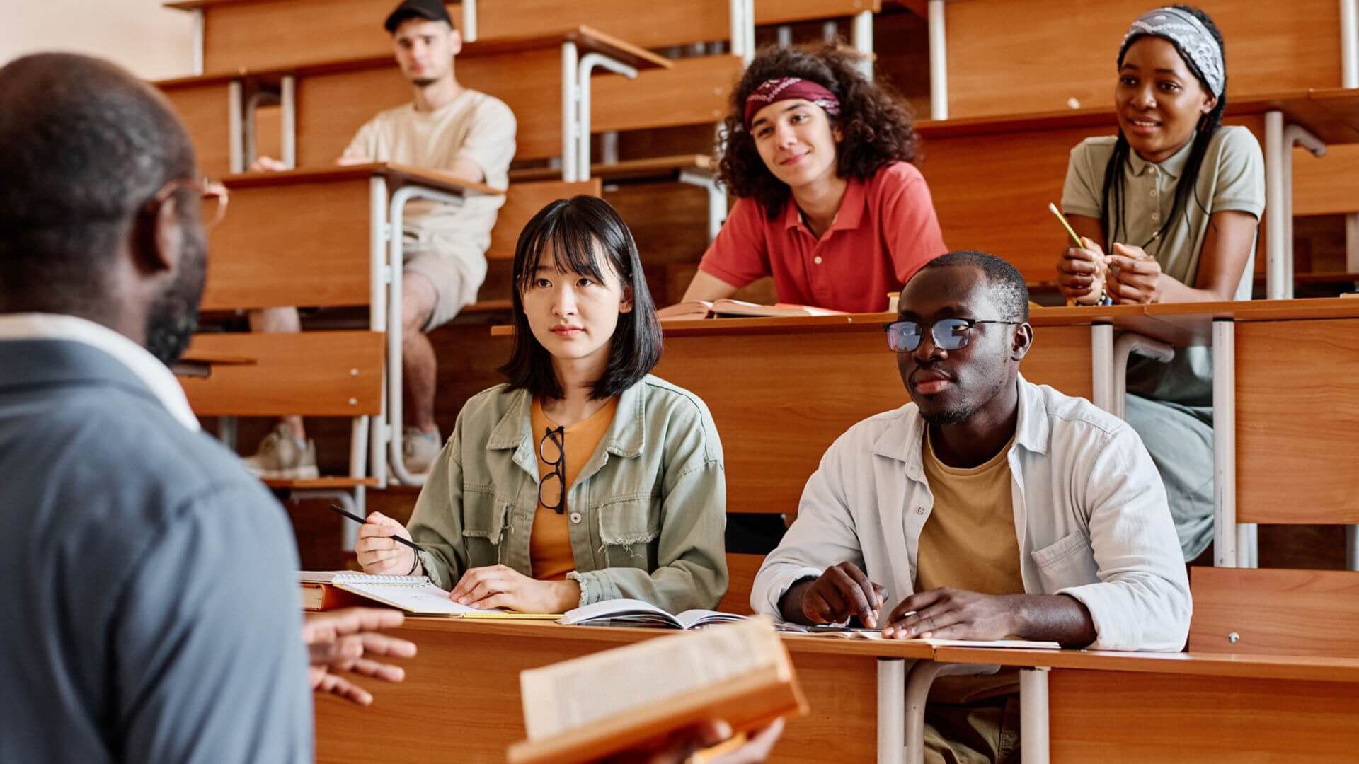 Students taking notes in a lecture hall. 