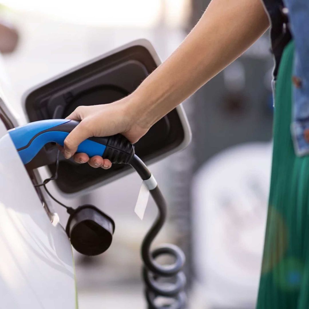 A hand plugging in an elective vehicle.