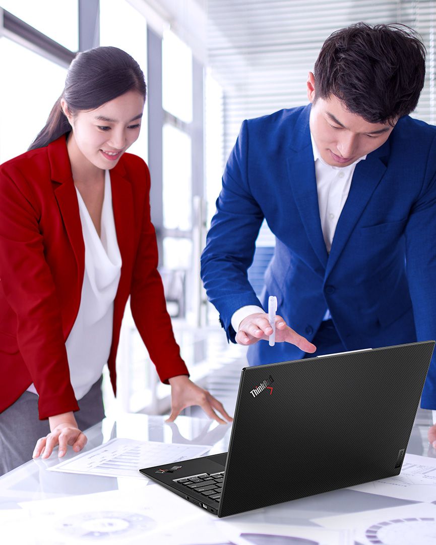 LenovoノートPCに向かって作業する男性が後ろにポストイットボードを置いています。