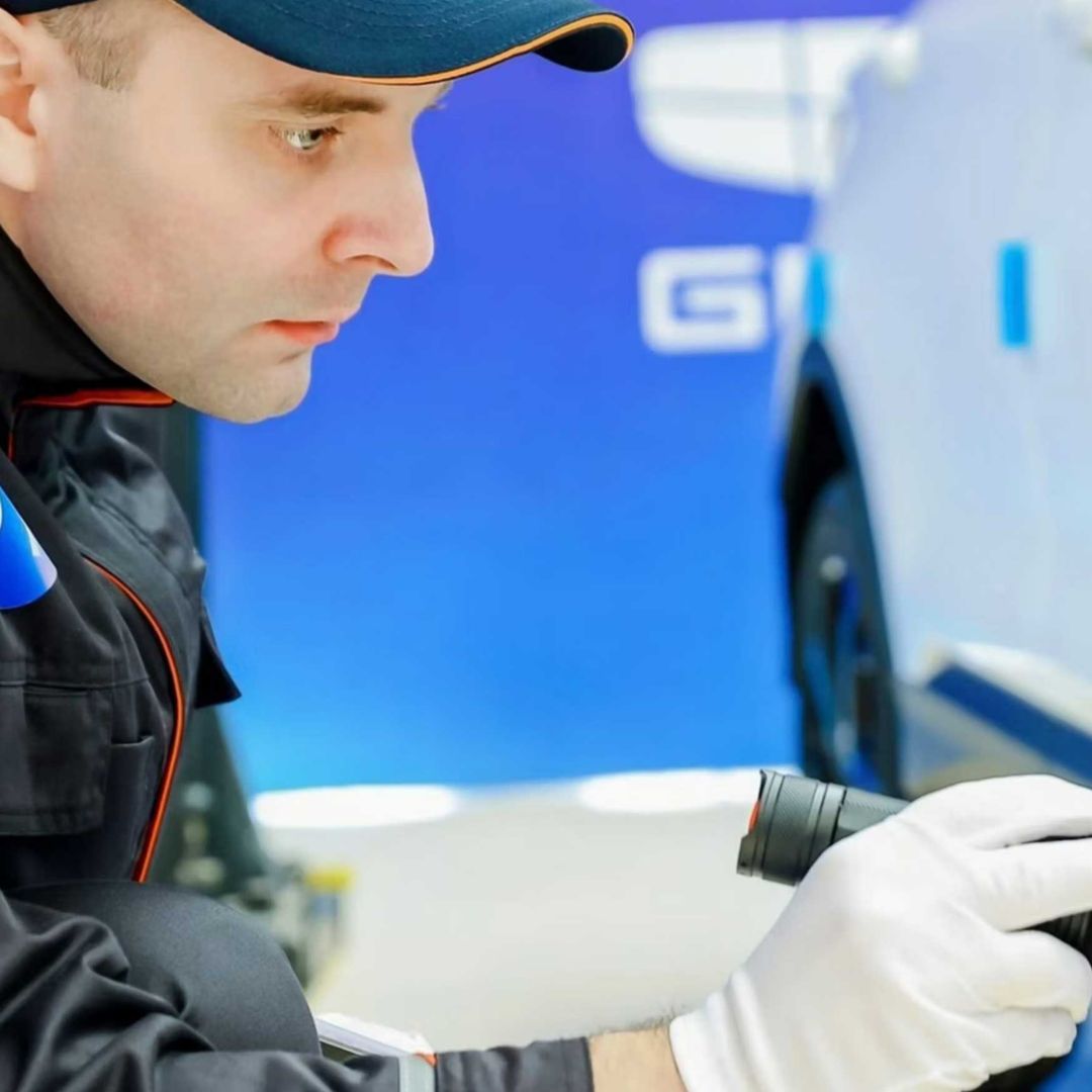 A Geely Auto R&D employee inspecting a vehicle.