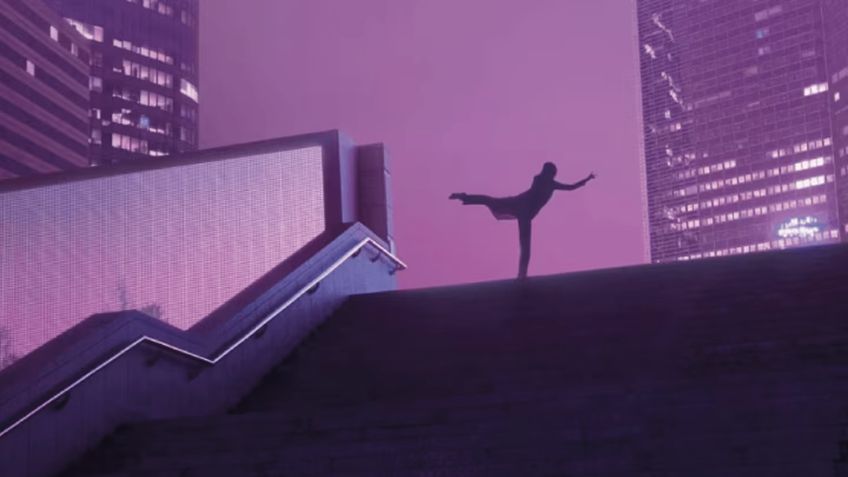 Silhouetted dancer poses on stairs against a purple-lit urban skyline.