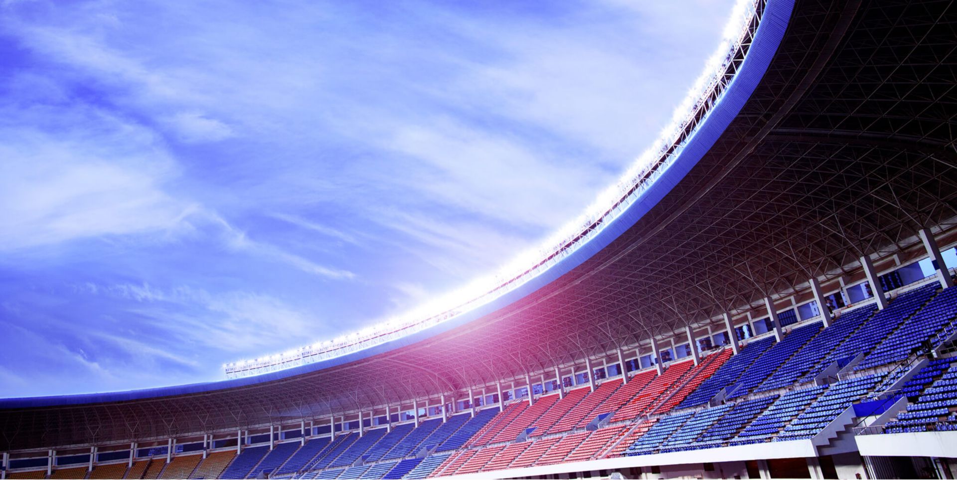 An empty stadium under a blue sky.