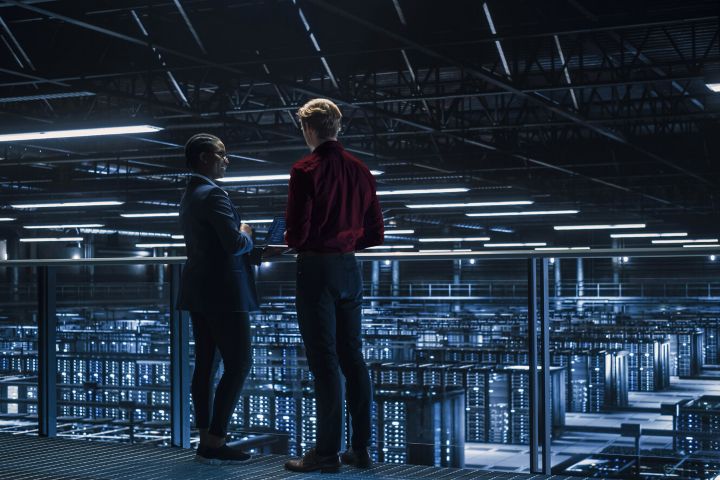 Two men overlooking a server room. 
