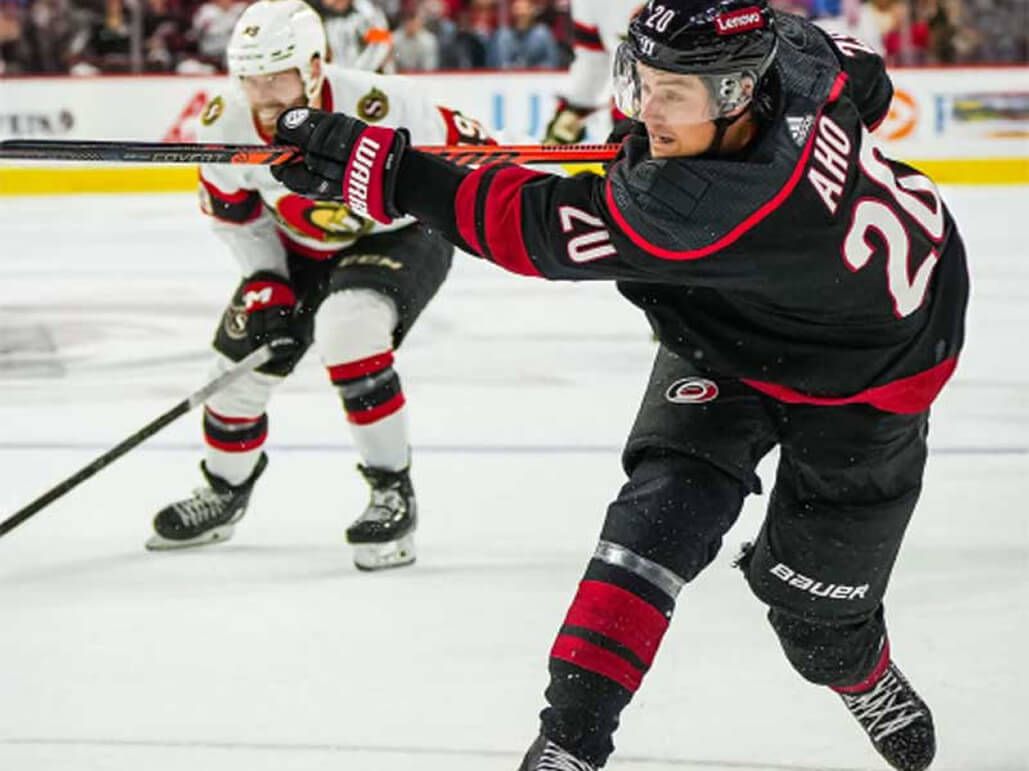 A Carolina Hurricanes player shooting the puck. 