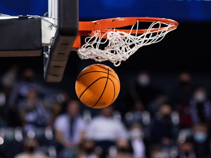 A basketball swishing through a hoop.