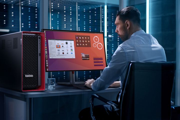 A man at a desk next to a server room, working on a ThinkStation.