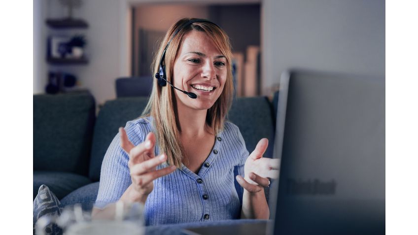 A woman talking on a headset at work.