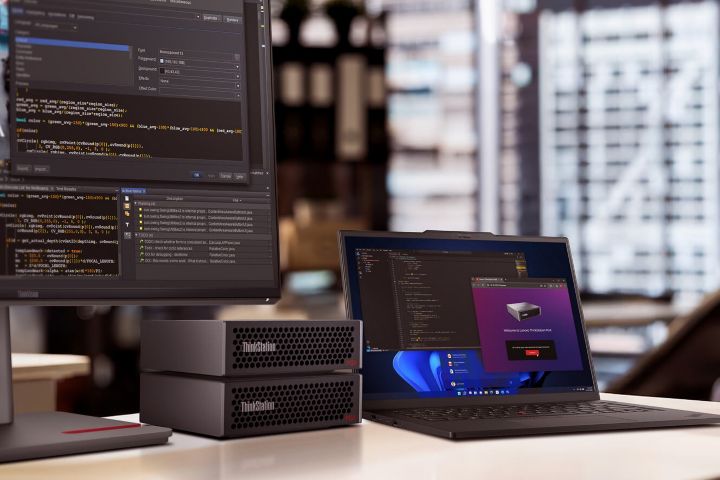 A monitor, two ThinkStations, and a laptop on a desk.