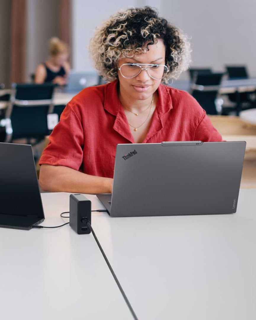 A woman using a ThinkPad at a conference. 