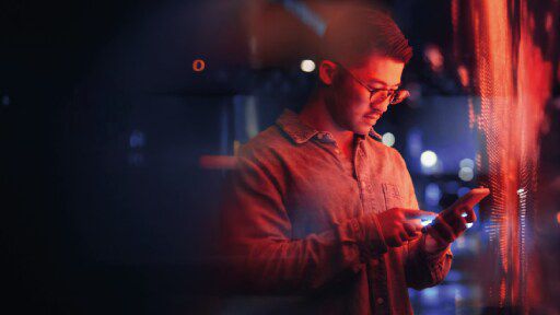 A man working on a tablet with red lights shining all around