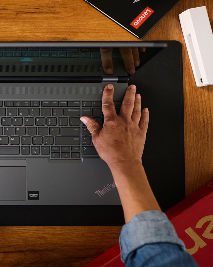 A finger powering on a laptop. 